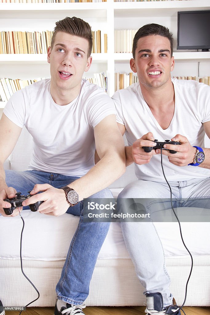 2 つのモダンな男遊ぶコンピュータゲーム保持コントローラ - ゲームパッドのロイヤリティフリーストックフォト
