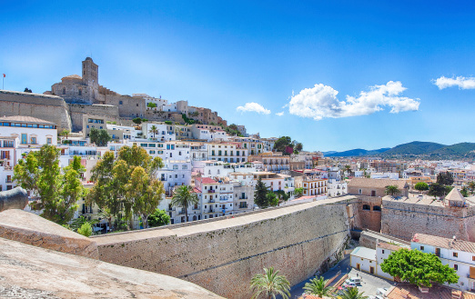 Sunny Panorama with a blue sky and few white clouds from the old town of Ibiza (old city of Eivissa) in Spain (Balearic Islands). Photo taken from the stone wall surrounding the city with a view of the Cathedral.