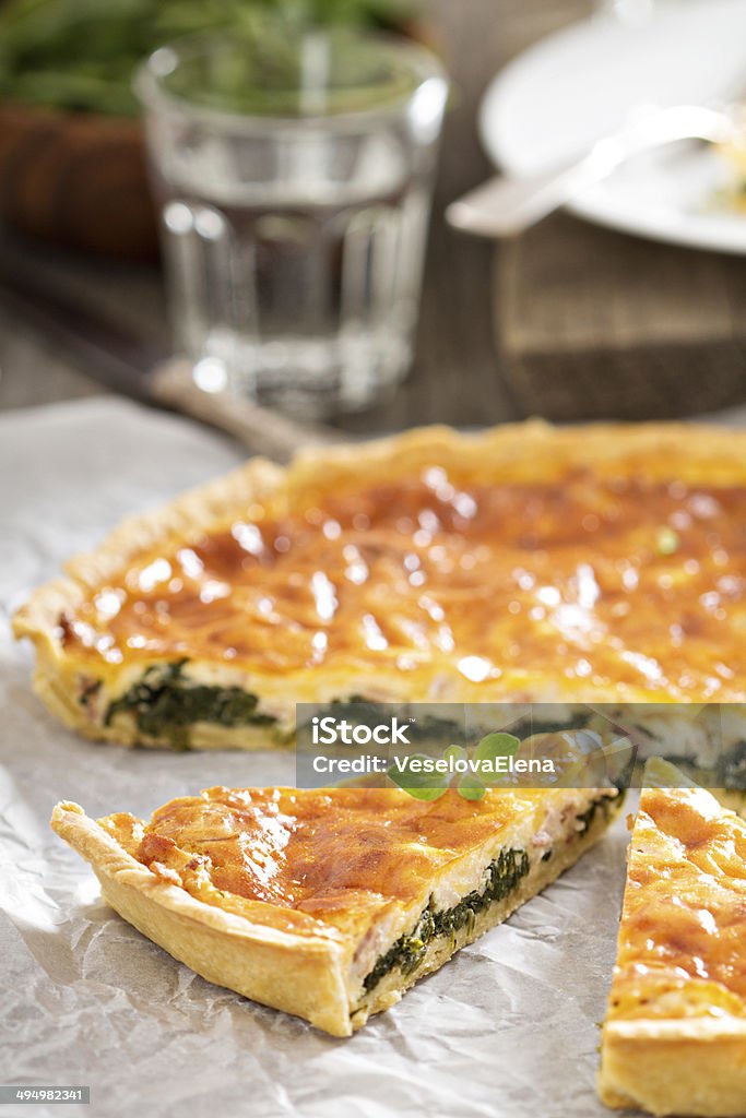 Quiche with arugula and bacon Quiche with cheese, arugula and bacon on a table Arugula Stock Photo