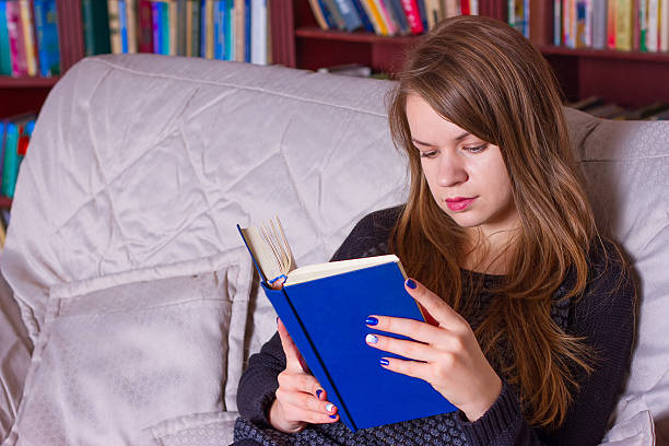 istock girl reading a book on the couch 494991222