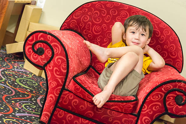istock Mixed Race Boy Relaxing in Comfortable Red Arm-Chair 494991956