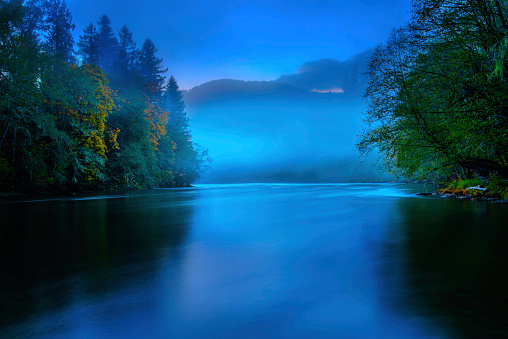 Night mystical scenery. Full moon over foggy river. Mysterious landscape.