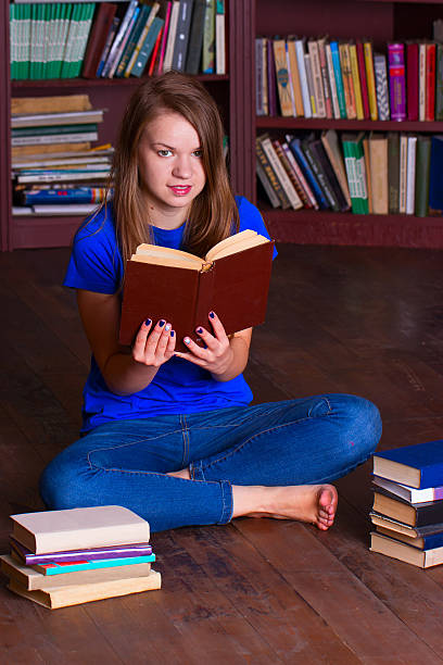 istock girl sits on floor in the library 494995308