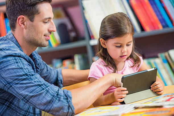 istock Little girl on digital tablet with father 494996078