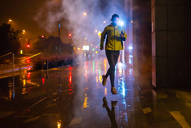 ensemble de femme de pluie dans la ville de nuit - courir sous la pluie photos et images de collection