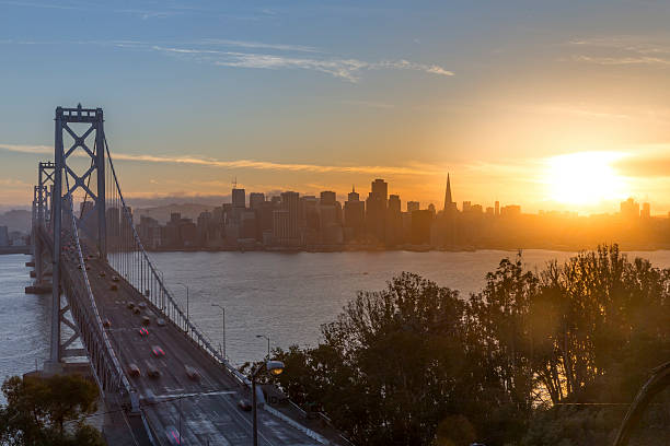 le pont bay bridge et san francisco, au coucher du soleil - san francisco county flash photos et images de collection