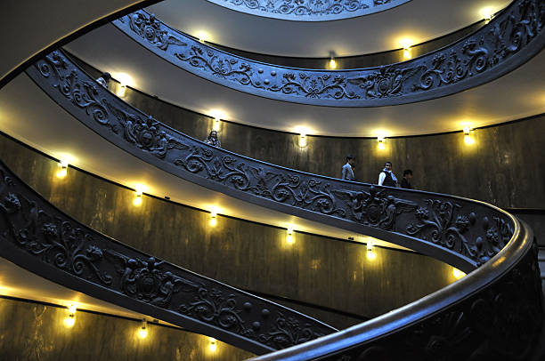 Rome, Italy - March 2013: The famous spiral staircase that leads to the exit of the vatican museum inside the vatican city. Tourists are walking down.