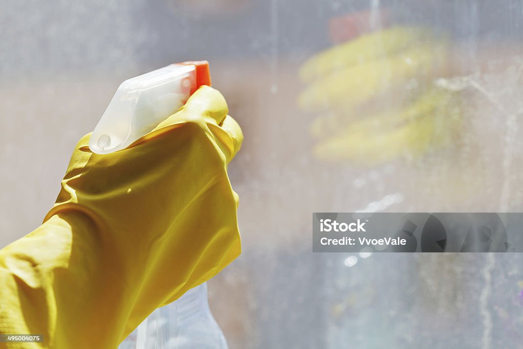 hand with cleaner spray bottle hand with cleaner spray bottle and its reflection in dirty window glass Bottle Stock Photo