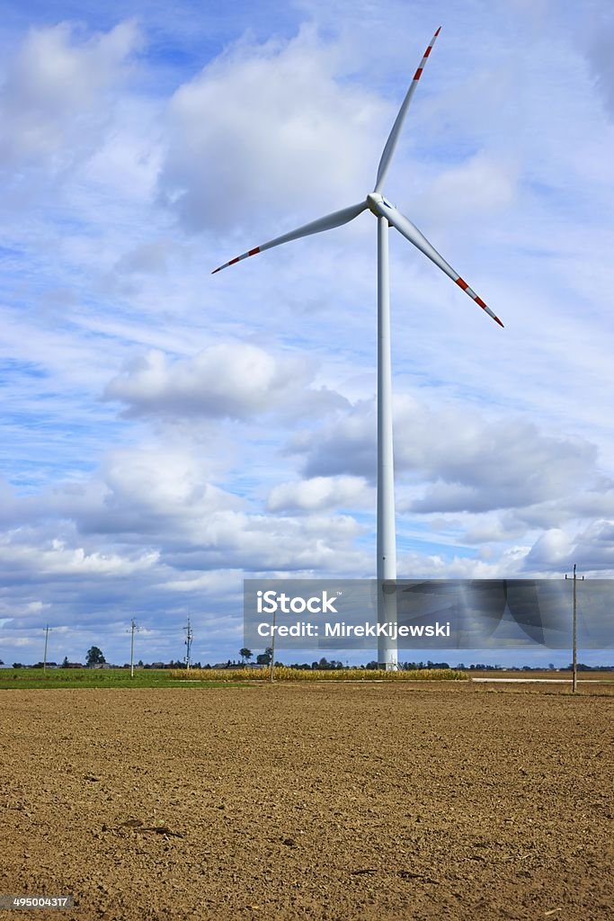 Molino de viento, turbina de pie en un campo arado - Foto de stock de Aerogenerador libre de derechos