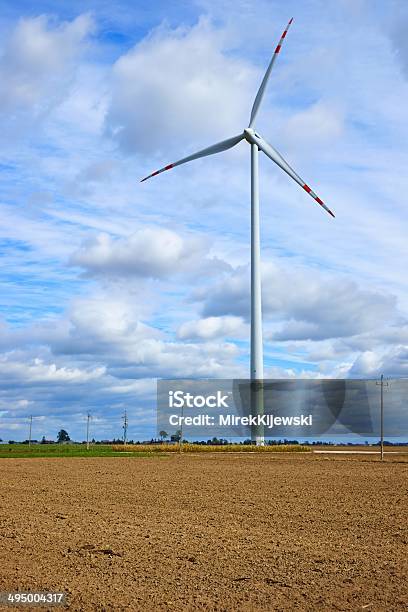 Molino De Viento Turbina De Pie En Un Campo Arado Foto de stock y más banco de imágenes de Aerogenerador - Aerogenerador, Agricultura, Aire libre