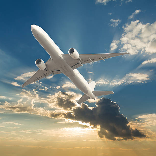 istock Commercial airplane flying with clouds and sun rays background 495017330