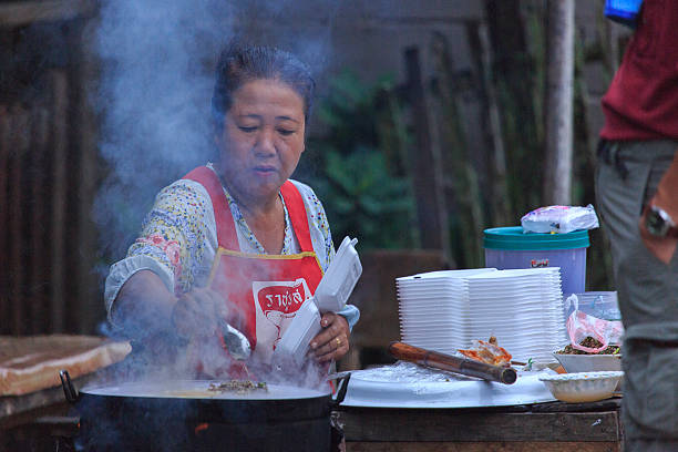 Luang Prabang, Laos - October 6, 2012: A street vendor prepares her food in Luang Prabang, Laos