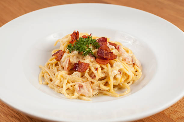 spaghetti alla cabonara in der tiefen runde platte - pasta cabonara stock-fotos und bilder