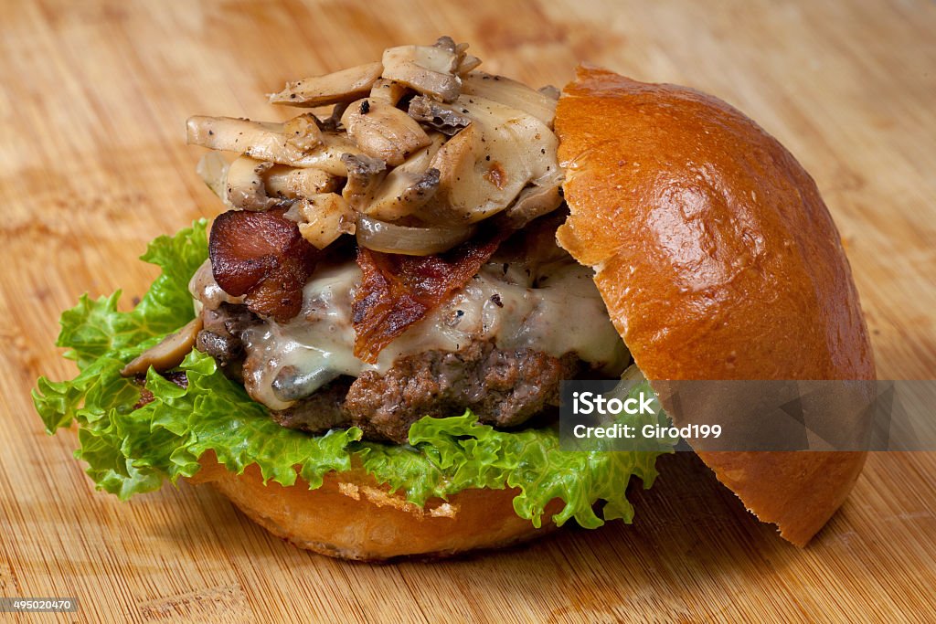 Mushroom Burger A big, juicy burger topped with mushrooms, bacon, cheese, and lettuce. Burger Stock Photo