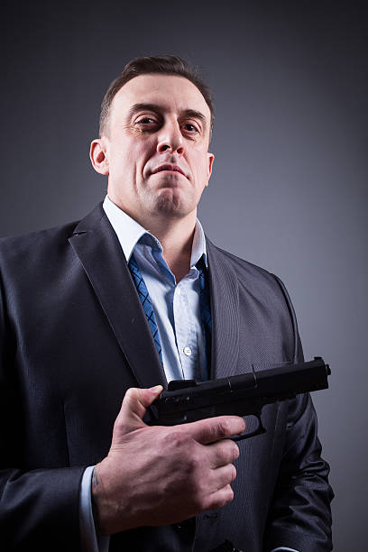 istock man in business suit with a gun 495020912