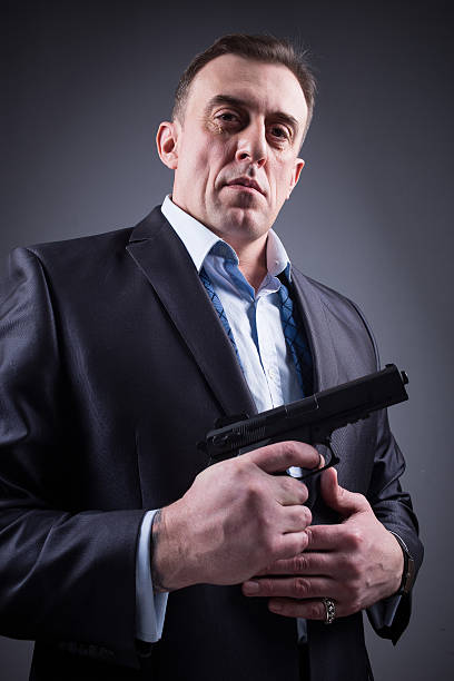 istock man in business suit with a gun 495020922