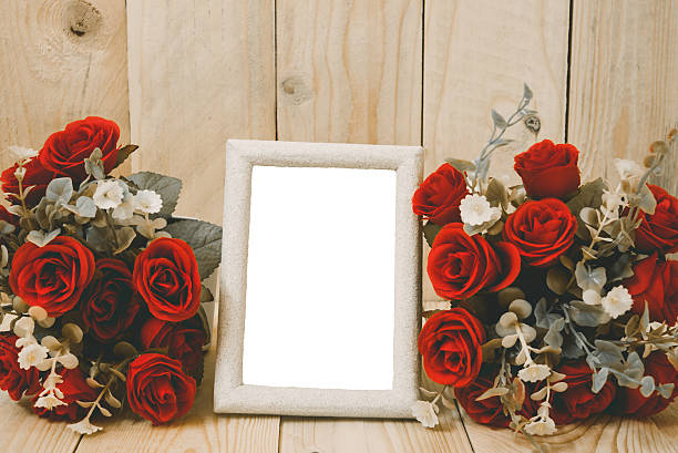 Old wooden picture frame with clipping path and red flowers
