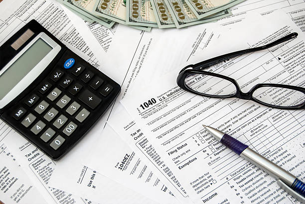 세금 양식을 펜, 안경, 달러 및 계산기 - tax form tax finance deductions 뉴스 사진 이미지