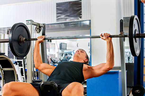 istock Man working his arms and chest at gym 495023448
