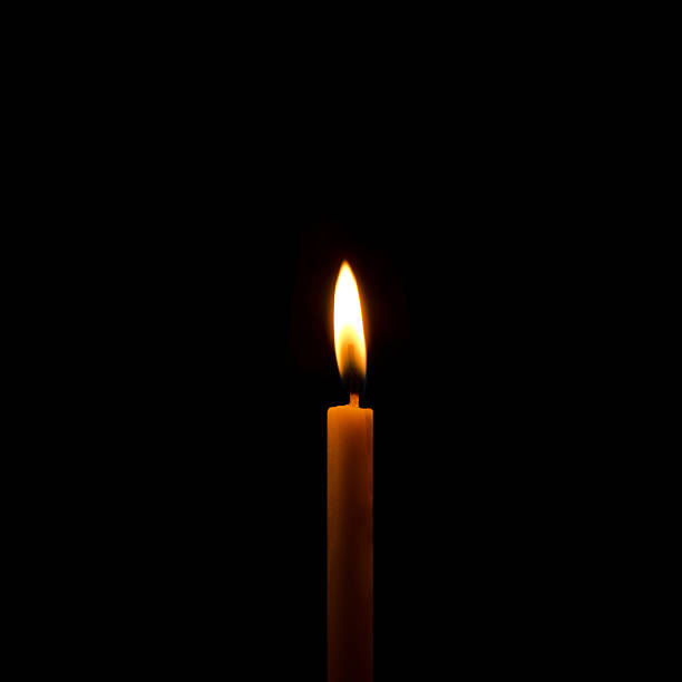 istock One light candle burning brightly in the black background 495034210
