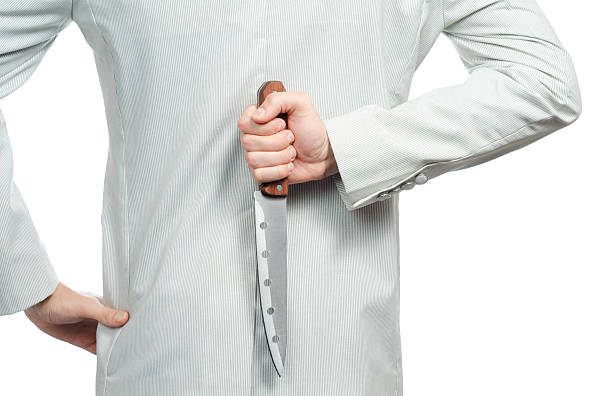 istock businessman with a knife behind his back 495038074