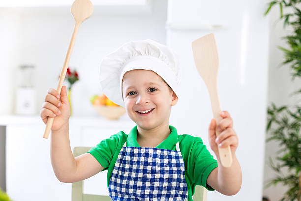 istock Young beautiful child with chef cap smiling and holding scoops 495039560