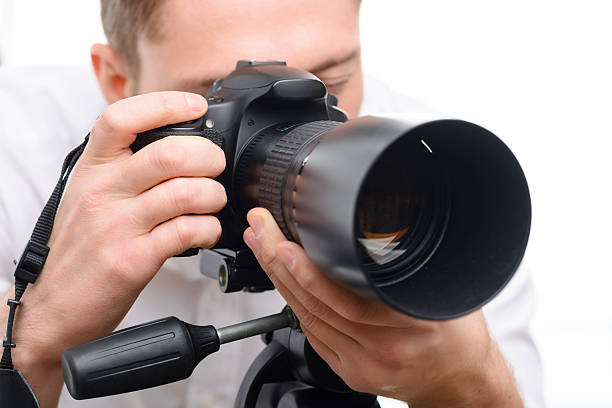istock Handsome photographer filming with professional camera 495053994