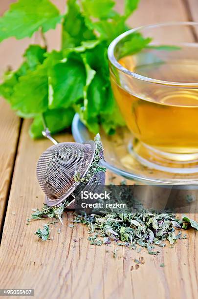 Herbal Tea From Melissa In Cup With Strainer On Board Stock Photo - Download Image Now