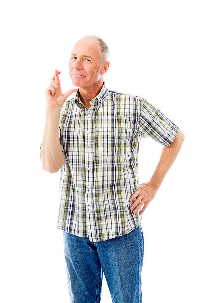 istock Senior man standing with finger crossed for luck 495057941