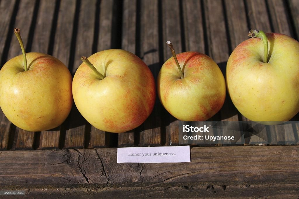 Honour your uniqueness Image showing a line of apples that are different sizes and shapes next to a quote 'honour your uniqueness. Apple - Fruit Stock Photo