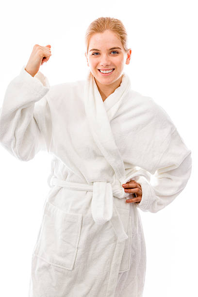 istock Young woman standing in bathrobe and flexing biceps 495061229