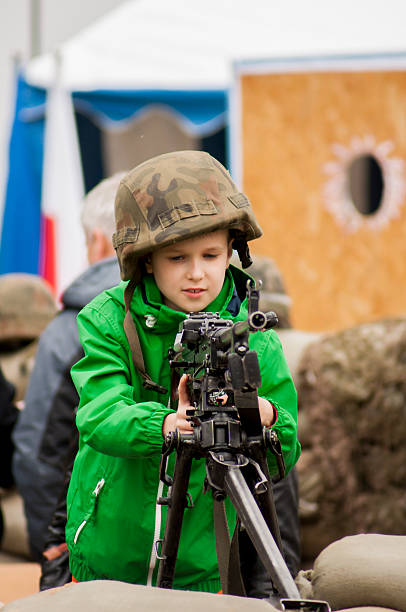 Young boy with machine gun Szczecin, Poland - Mai 29, 2014: Veterans Day in Poland. Unidentified young boy holds the hand machine gun.He has on his head a military helmet. special forces vietnam stock pictures, royalty-free photos & images