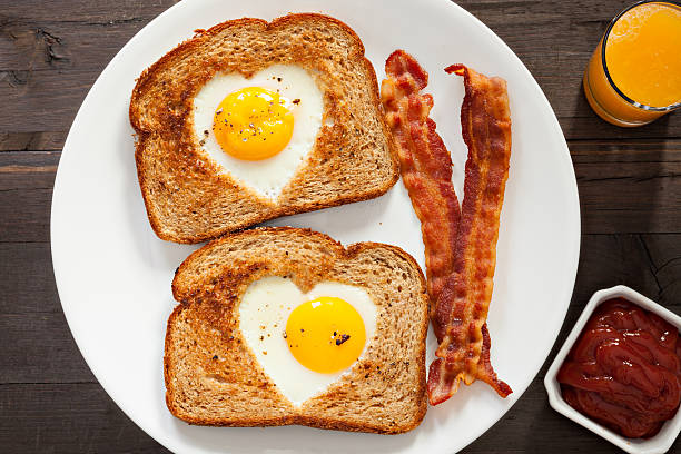 en forma de corazón huevos, pan tostado - eggs breakfast heart shape fried egg fotografías e imágenes de stock