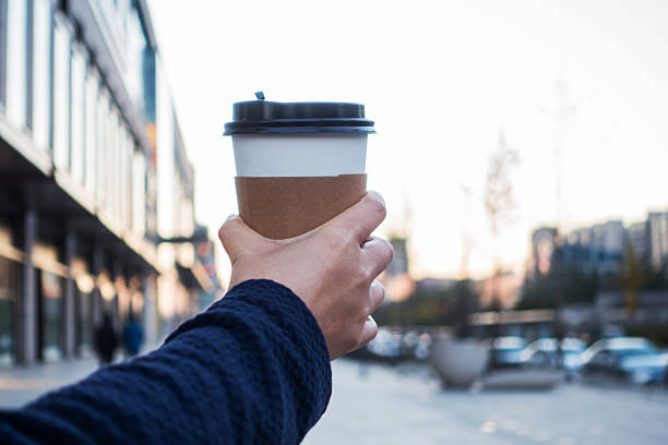 istock holding a disposable cup of coffee 495064056