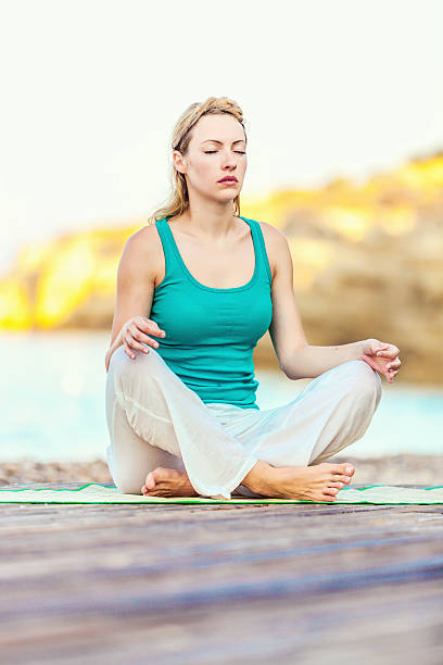 istock Woman practicing yoga at beach 495065246
