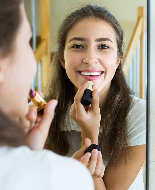 istock Teenager applying lipstick 495068254