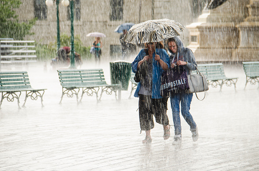 Quebec City, Canada - July 27, 2014: Two Women walk under umbrella during heavy rain in Quebec City, Canada, next to Chateau Frontenac.