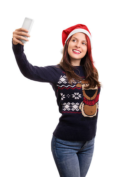 istock Young girl with a christmas hat taking a selfie 495077438
