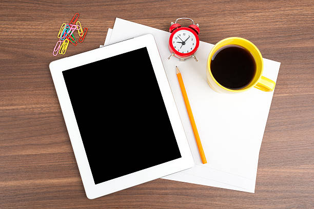 istock Tablet with blank paper and alarm clock 495080460