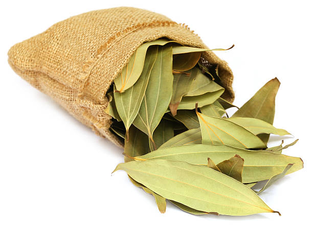 Cassia leaves in sack Cassia leaves in sack over white background bay leaf stock pictures, royalty-free photos & images