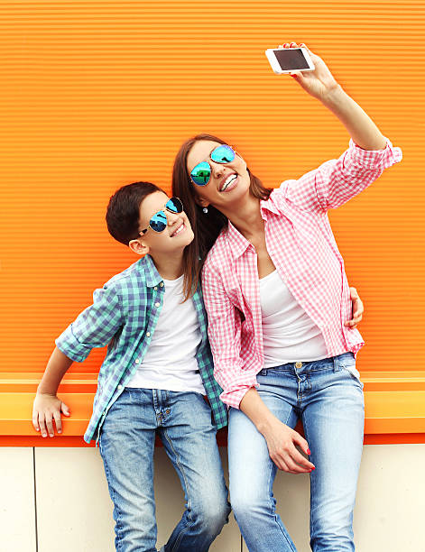 szczęśliwa matka i syn, biorąc zdjęcie z smartphone siebie portret - fun mother sunglasses family zdjęcia i obrazy z banku zdjęć