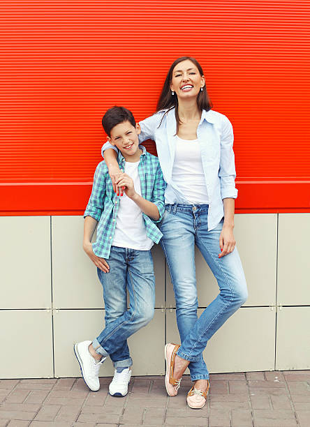 felice madre e figlio adolescente indossando abiti casual in città - laughing women shirt vertical foto e immagini stock