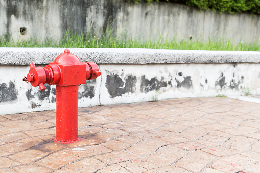 Red fire hydrant at strategic busy walk pavement ready for emergency