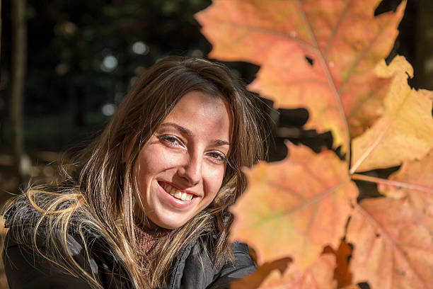 istock Young woman plays with branches with autumn leaves 495085248