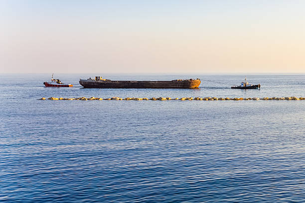 два tugboats транспортировка в баржа. - barge beach large blue стоковые фото и изображения