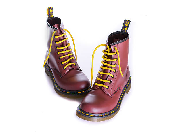 Classic cherry red oxblood Doc Martens lace-up boots New York, USA - October 28, 2015: A pair of Doc Martens 8 eyelet 8 inch classic unisex cherry red oxblood lace-up fashion combat boots with yellow laces lace up stock pictures, royalty-free photos & images