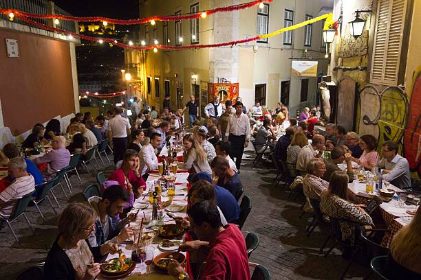 Lisbon, Portugal - October 23, 2014: People having dinner outdoor in Calcada do Duque in Lisbon, with Sao Jorge Castle in the background