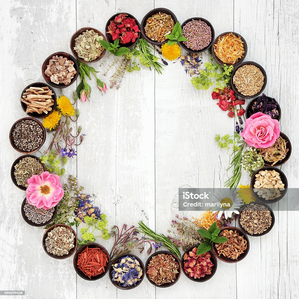 Medicinal Flowers and Herbs Natural flower and herb selection used in herbal medicine in bowls and loose forming a circle over distressed wooden background. Harpagophytum procumbens Stock Photo