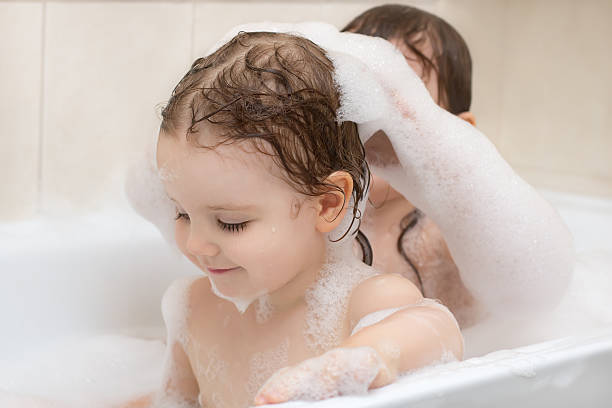 istock Two adorable little girls taking a bath with soap suds 495109490