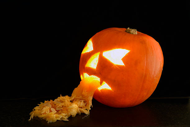 Haloween Pumpkin face. A Haloween Pumpkin face. A Pumpkin hollowed out and carved into a scary face. The hollowed out Pumpkin has been made to look like sick coming out of the mouth. pumpkin throwing up stock pictures, royalty-free photos & images